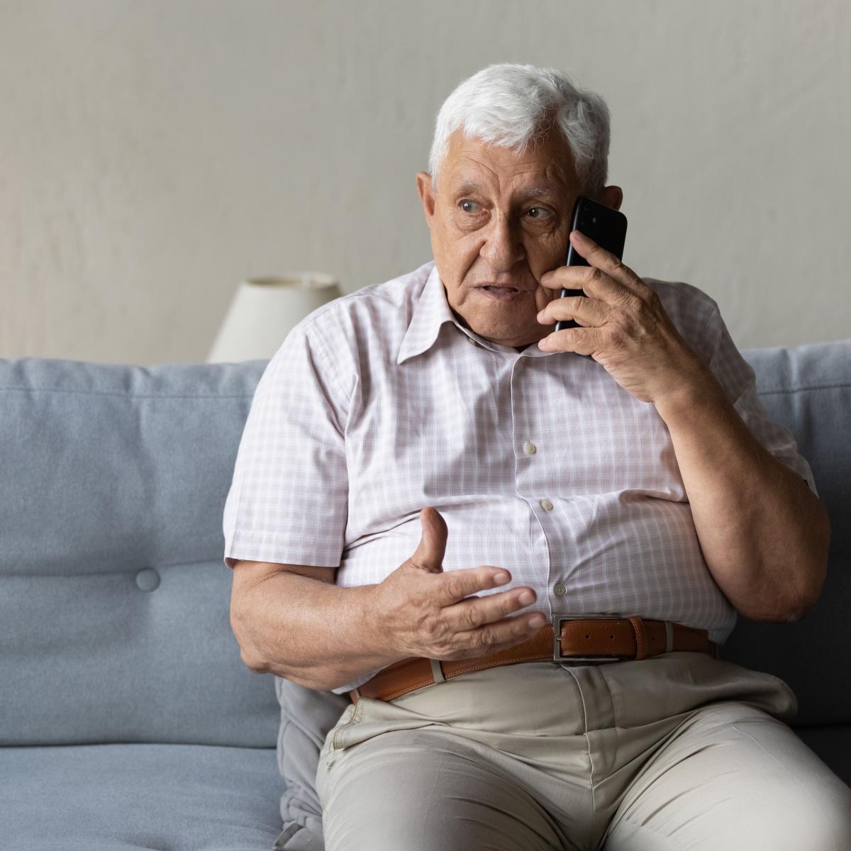 Older Man Talking on Phone while Sitting on Couch
