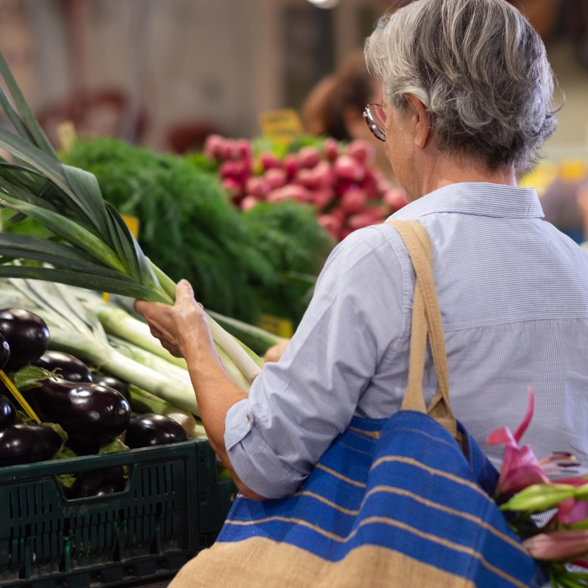 Older Woman Looking at Produce at Farmers Market