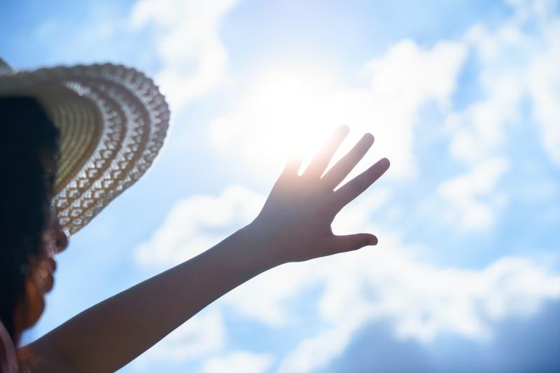 Older adult shielding sun from face