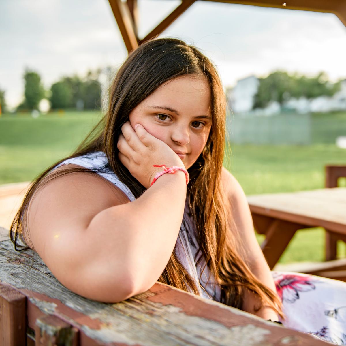 Young adult with disabilities sitting outside in the sunlight